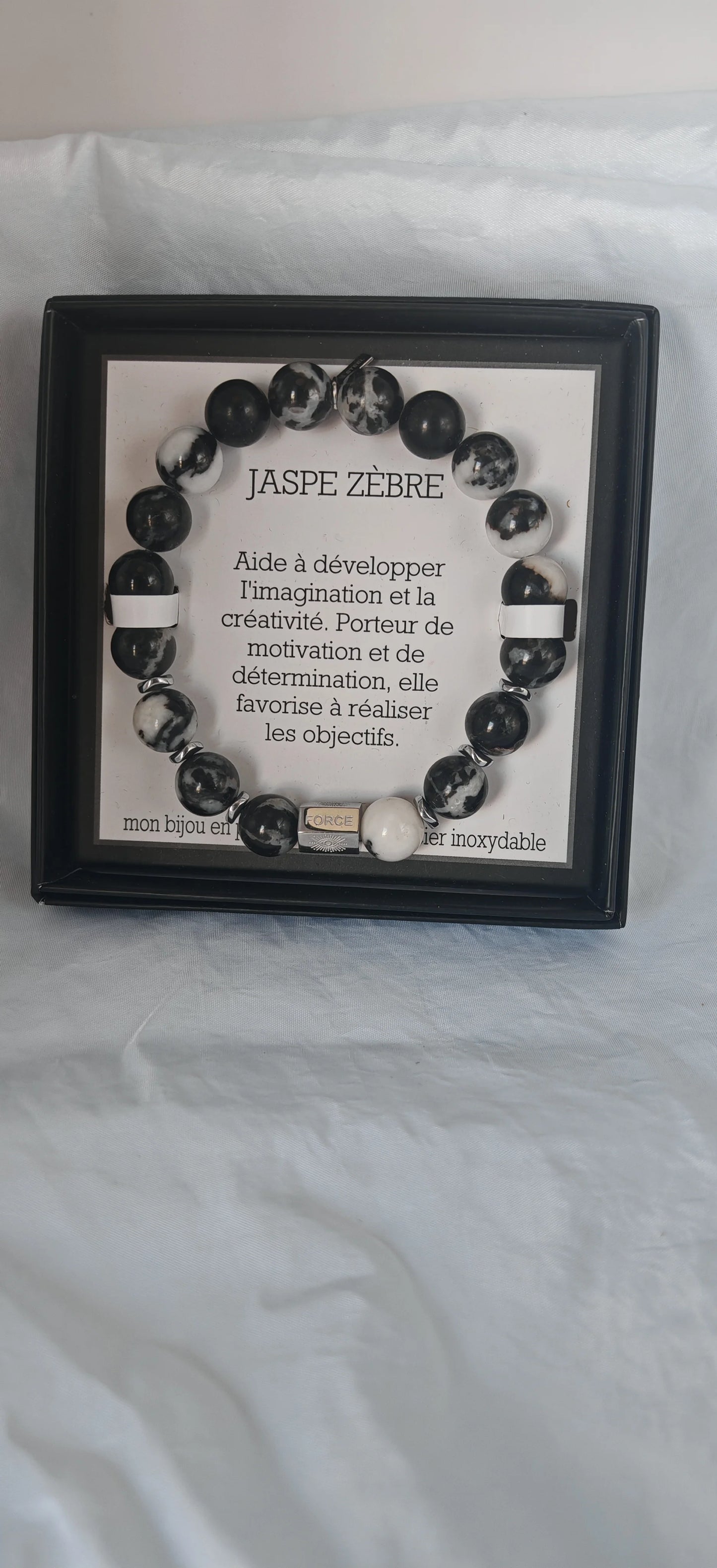 🪨 La puissance du jaspe zèbre
Le jaspe zèbre est une pierre naturelle unique, aux motifs noirs et blancs qui rappellent la peau de l’animal dont il tire son nom. Cette pierre d’ancrage est reconnue pour stimuler la motivation, aider à dépasser les obstacles et favoriser la stabilité émotionnelle.
Monté sur un fil élastique solide, ce bracelet s’adapte facilement à tous les poignets, pour un port confortable, sans contrainte.