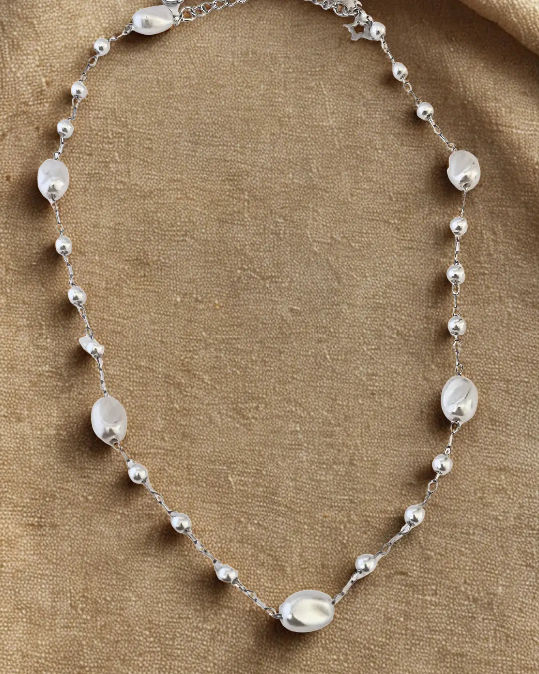 Collier délicat en acier inoxydable argenté avec perles blanches. Élégant, intemporel et résistant à l’eau, idéal pour un style chic au quotidien.