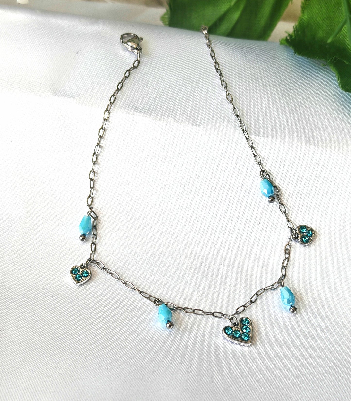 Fabriqué en acier inoxydable de qualité supérieure, ce bracelet de cheville brillant comporte des pampilles en forme de cœur ornées de strass bleus et de perles bleues. Léger et durable, il ajoutera une touche élégante et féminine à toute tenue. Parfait pour les occasions spéciales ou pour le quotidien.