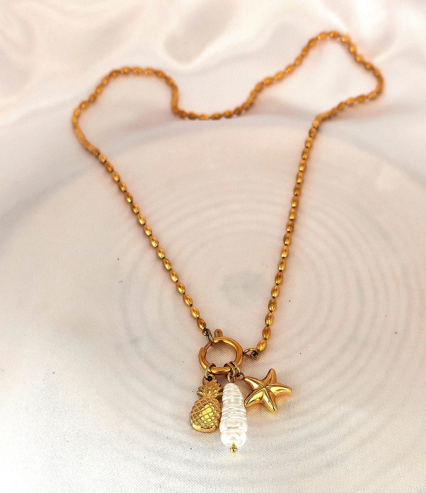 🌞 Un design frais et délicat
Ce collier en acier inoxydable est sublimé par une adorable pampille en forme d’ananas, finement travaillée pour un rendu léger et élégant. Son design frais et minimaliste en fait un bijou facile à porter au quotidien, que ce soit en vacances, en ville ou pour illuminer une tenue décontractée.
Waterproof, hypoallergénique et résistant, ce collier garde tout son éclat au fil du temps.