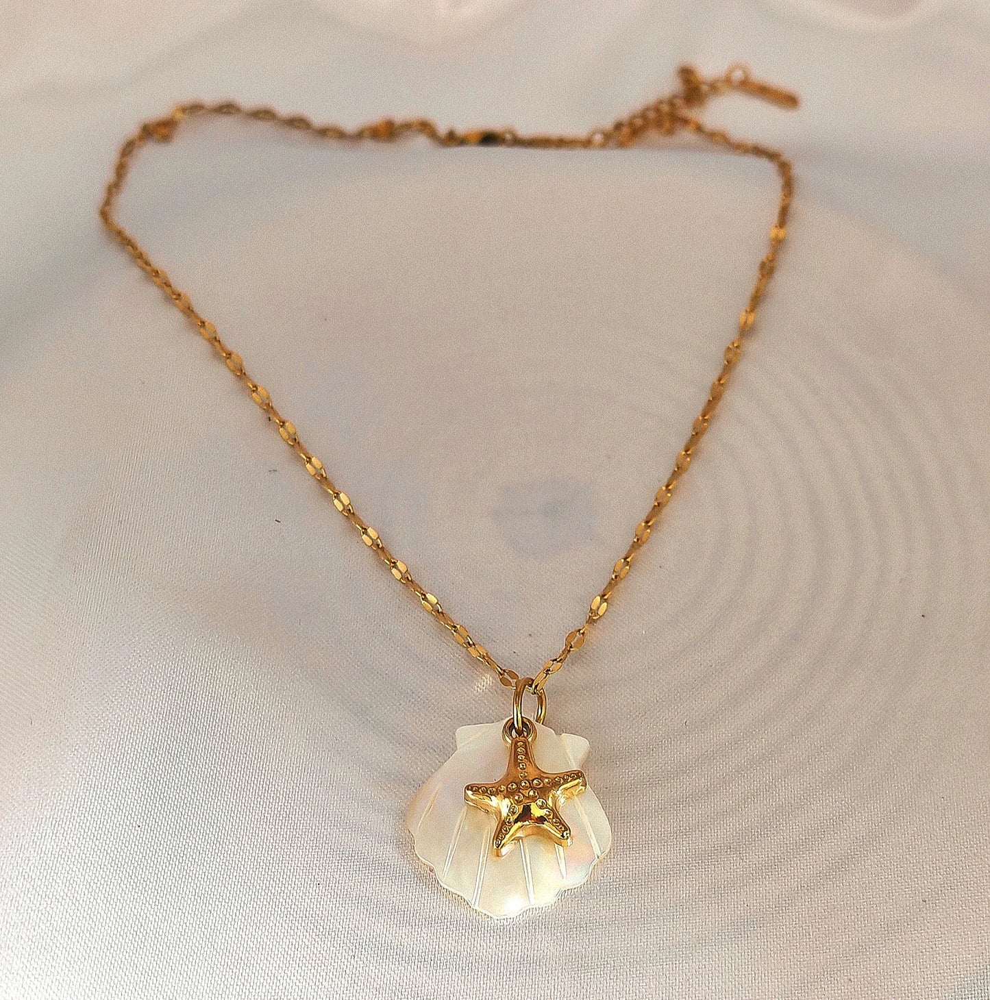 🌊 Un design naturel et raffiné
Ce collier délicat se compose d’une chaîne en acier inoxydable ornée d’un pendentif en forme de coquillage, subtilement nacré. Ses reflets doux et lumineux apportent une note chic et intemporelle, parfaite pour sublimer aussi bien une tenue estivale qu’un look de tous les jours.
Waterproof, hypoallergénique et durable, il est conçu pour résister à la vie quotidienne sans perdre son éclat.
C’est le bijou idéal pour les amoureuses de la mer et des accessoires minimalistes ave