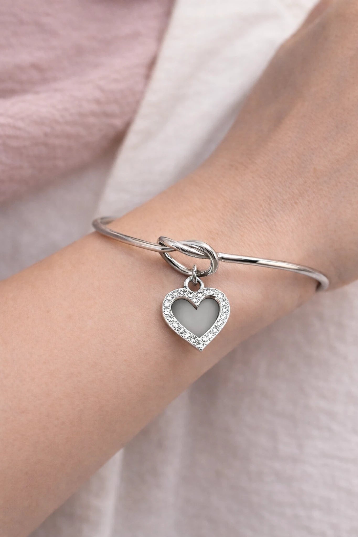 n jonc en acier inoxydable argent orné d’un cœur strassé, symbole d’amour et d’élégance intemporelle.