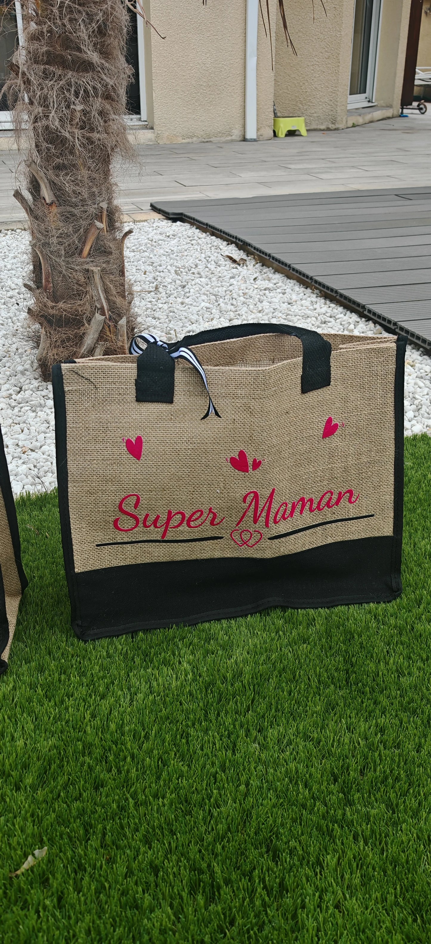 💪 Pour la Super Maman du quotidien
Elle porte le monde sur ses épaules… et ce sac sur son bras !
Ce sac cabas Super Maman est l’accessoire idéal pour toutes les mamans extraordinaires. Fabriqué en jute naturelle résistante avec de larges anses renforcées, il accompagne les journées bien remplies avec style et solidité. Son message “Super Maman” joliment imprimé sur le devant rend hommage à toutes celles qui jonglent entre amour, travail, famille et douceur… sans jamais poser leur cape.
