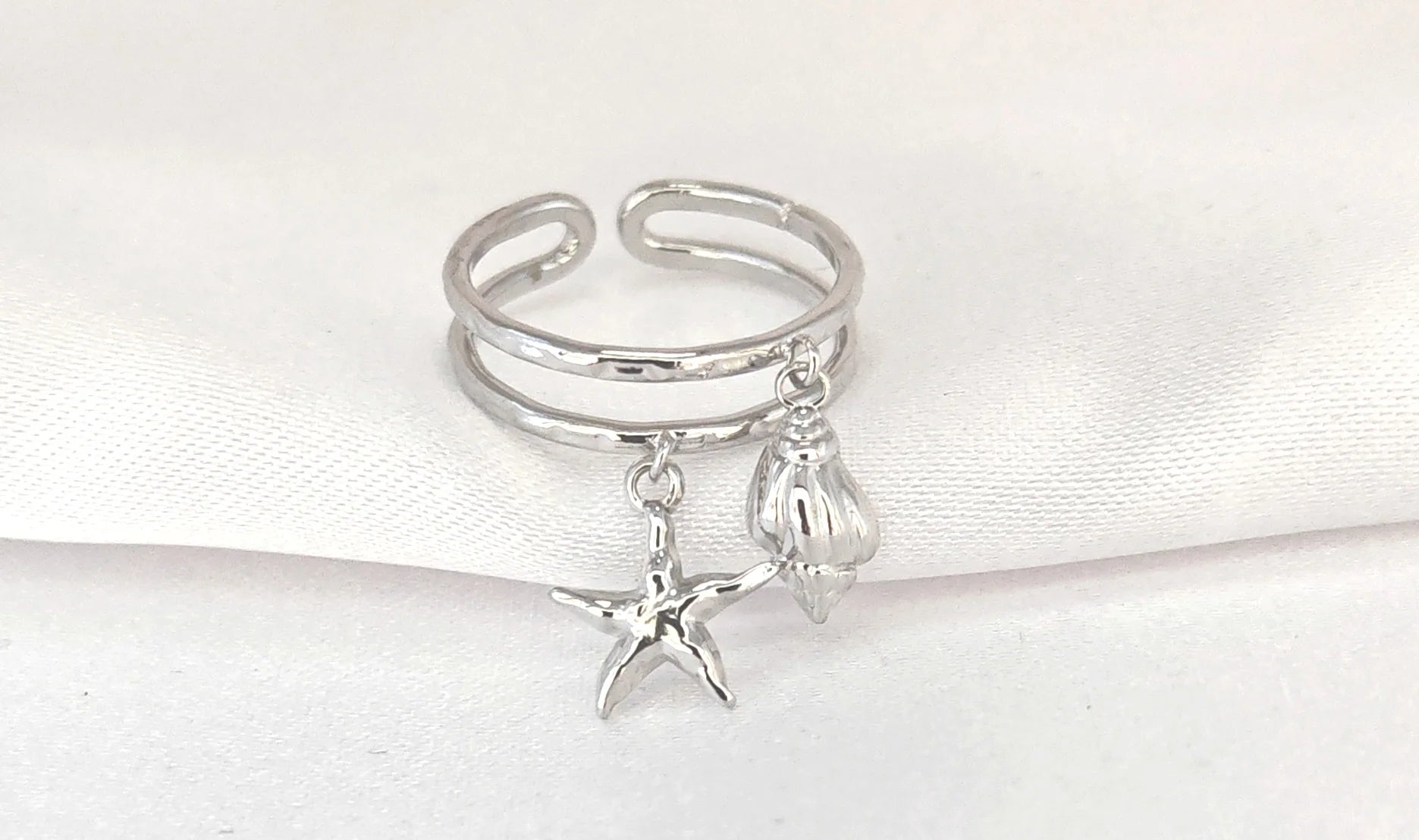 🌊 Un souffle marin à portée de main
Un bijou qui sent bon les vacances, le sable chaud et la liberté.

Cette bague coquillage étoile de mer réglable est une invitation à l’évasion. Finement travaillée en acier inoxydable, elle s’orne de deux pampilles symboliques : un coquillage délicat et une étoile de mer, véritables porte-bonheur marins. Légère, élégante et entièrement ajustable, elle se glisse à n’importe quel doigt pour une touche bohème et estivale à votre look