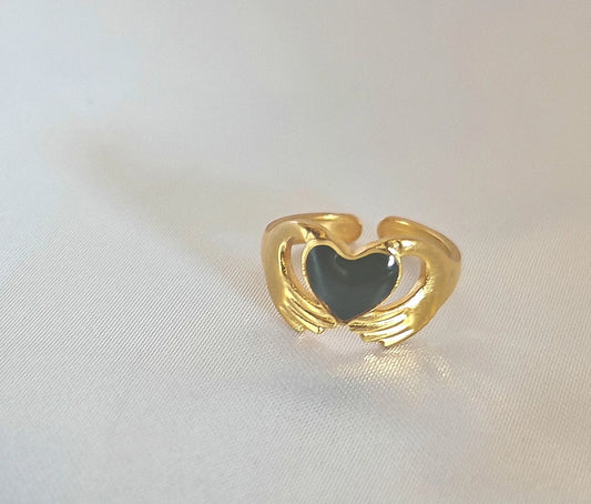 Cette bague délicate en acier inoxydable doré représente un cœur tendrement enlacé dans des bras stylisés, comme une caresse éternelle. Elle incarne l’amour, la tendresse et la protection — parfaite pour symboliser un lien précieux.

Avec sa forme ajustable, elle s’adapte à toutes les mains tout en conservant une finesse visuelle. Résistante à l’eau, hypoallergénique et conçue pour durer, elle vous accompagne au quotidien sans s'altérer.