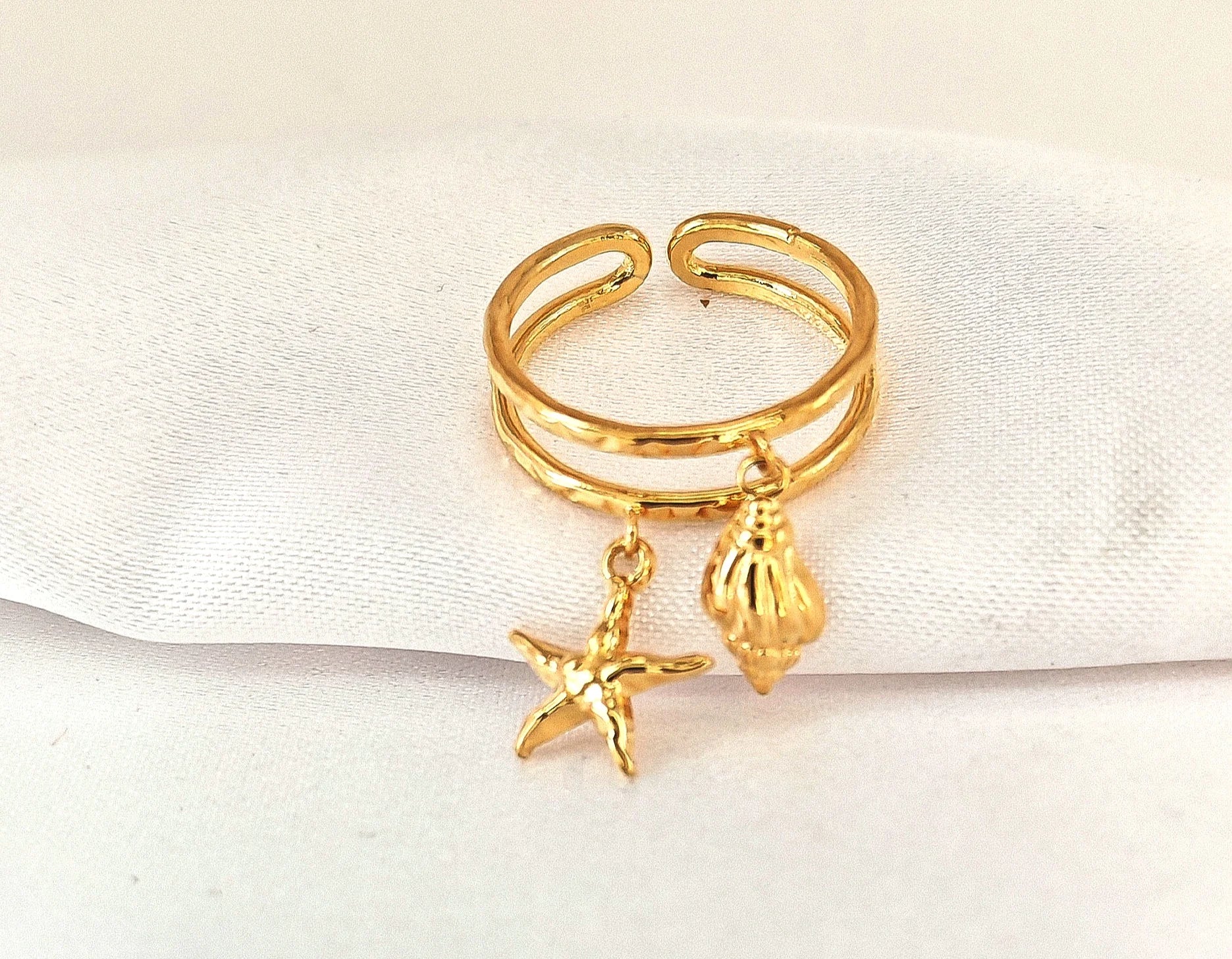 🌊 Un souffle marin à portée de main
Un bijou qui sent bon les vacances, le sable chaud et la liberté.

Cette bague coquillage étoile de mer réglable est une invitation à l’évasion. Finement travaillée en acier inoxydable, elle s’orne de deux pampilles symboliques : un coquillage délicat et une étoile de mer, véritables porte-bonheur marins. Légère, élégante et entièrement ajustable, elle se glisse à n’importe quel doigt pour une touche bohème et estivale à votre look