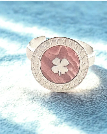 Portez la chance à votre doigt avec cette bague argentée au design raffiné. Son médaillon rond révèle un fond nacré rose doux, orné d’un trèfle délicat, symbole de chance et de positivité. Un bijou à la fois élégant et plein de sens, idéal pour illuminer vos journées.