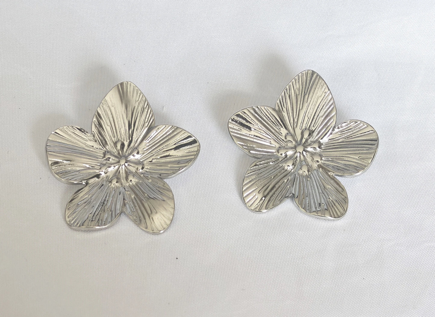 Inspirées des pétales de fleurs, les boucles Flora allient finesse et durabilité grâce à leur conception en acier inoxydable de qualité. Elles sont waterproof, ne noircissent pas et hypoallergéniques, parfaites pour un port quotidien sans compromis sur le confort ni la résistance.

Discrètes mais pleines de charme, elles sont idéales pour accessoiriser une tenue élégante, une robe bohème ou un look casual chic.