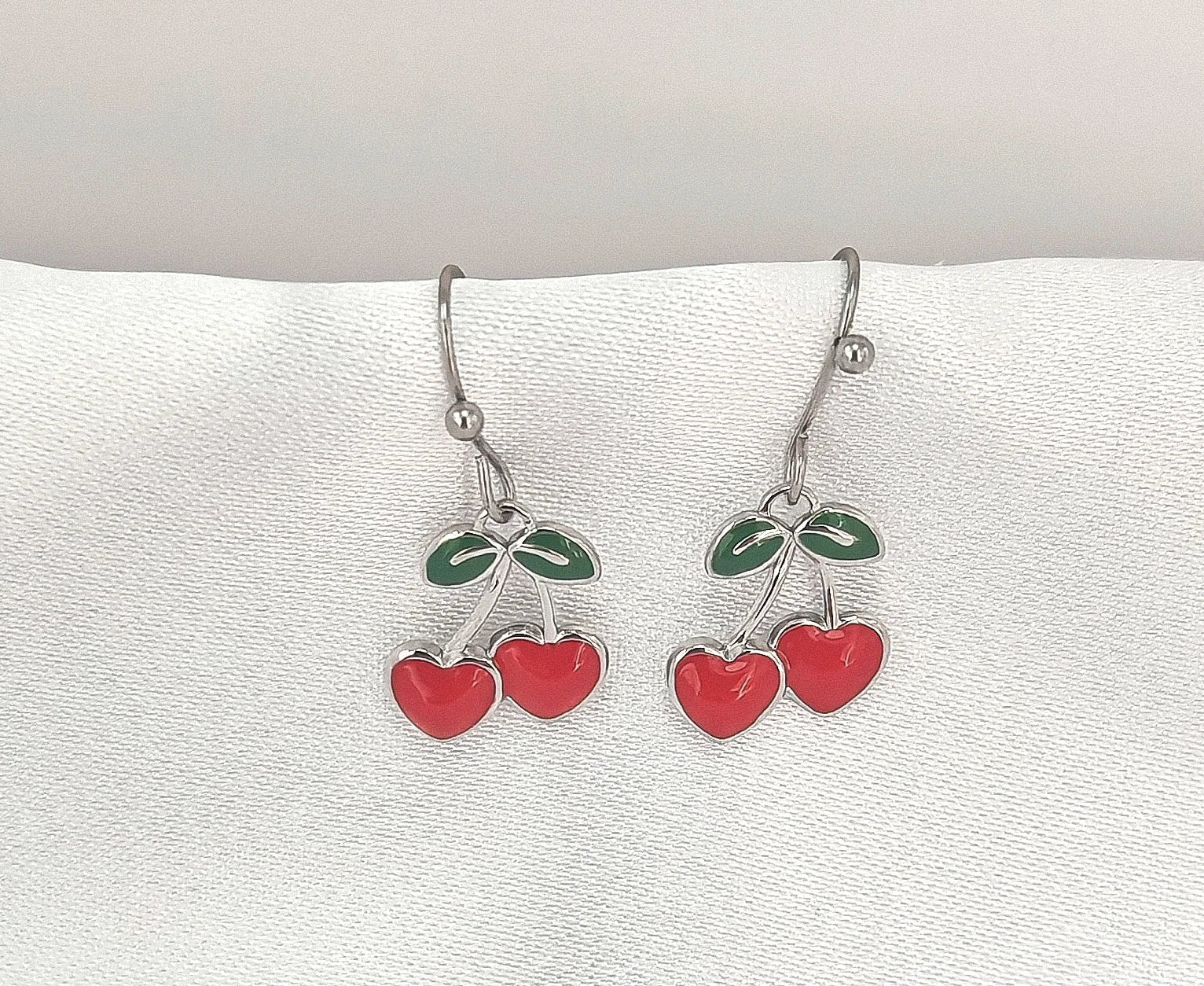 🍒 Un brin rétro, une touche pop, un bijou qui pétille

Des boucles d’oreilles qui ne passent pas inaperçues – fraîches, fruitées, féminines.

Ces boucles d’oreilles cerise pendantes sont la définition même du bijou ludique et stylé. Inspirées des années 60 avec une touche contemporaine, elles arborent deux jolies cerises rouges émaillées suspendues à de fines tiges dorées en acier inoxydable. Ultra légères et confortables, elles oscillent délicatement à chaque mouvement, ajoutant une note gourmande, audaci
