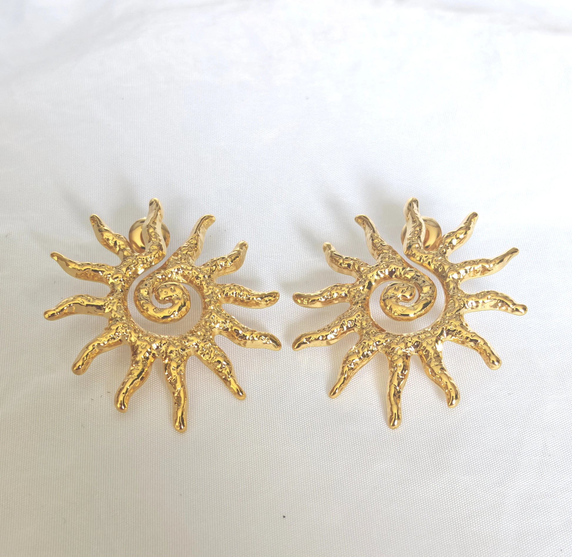 Les boucles Helios se distinguent par leur forme éclatante, inspirée des rayons du soleil. Fabriquées en acier inoxydable de haute qualité, elles sont waterproof, ne noircissent pas et résistent à la vie quotidienne sans perdre leur éclat.

Que vous les portiez seules pour un look chic minimaliste ou en accumulation avec d’autres bijoux, elles illumineront instantanément votre visage.