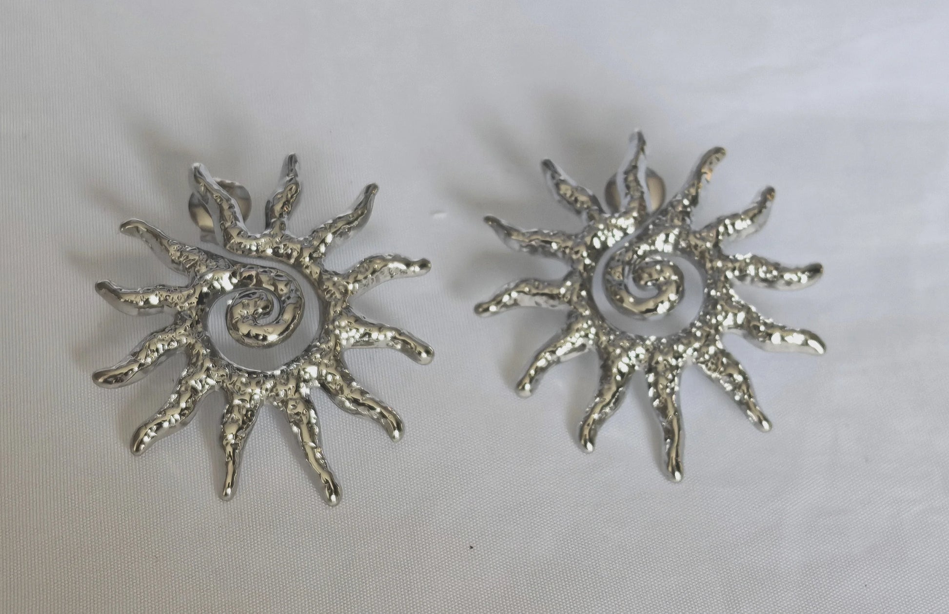 Les boucles Helios se distinguent par leur forme éclatante, inspirée des rayons du soleil. Fabriquées en acier inoxydable de haute qualité, elles sont waterproof, ne noircissent pas et résistent à la vie quotidienne sans perdre leur éclat.

Que vous les portiez seules pour un look chic minimaliste ou en accumulation avec d’autres bijoux, elles illumineront instantanément votre visage.