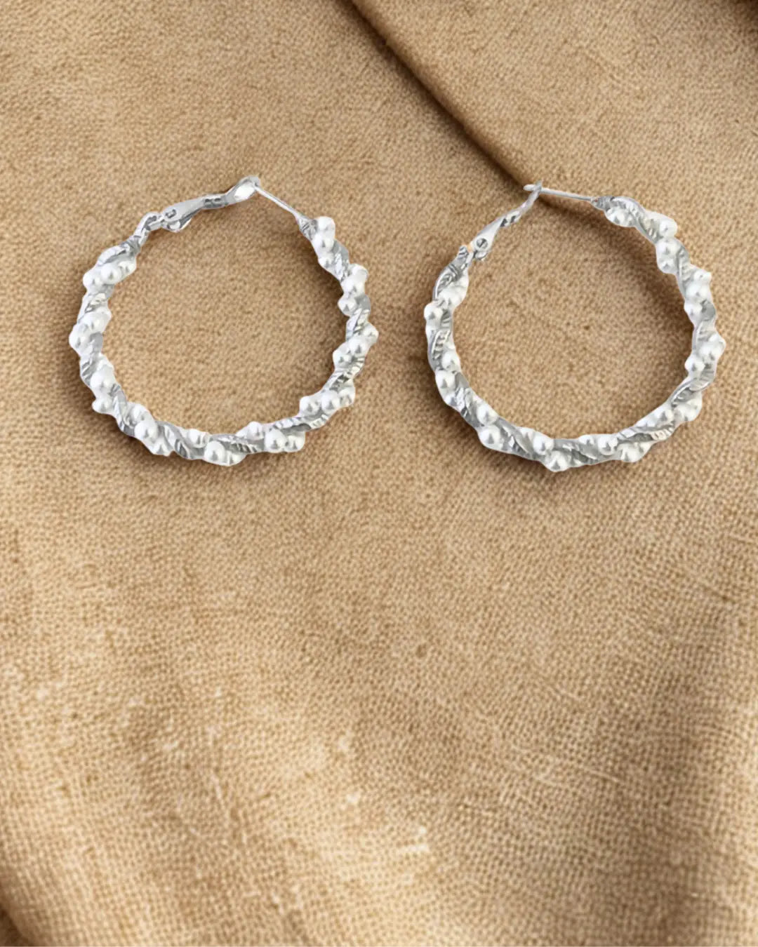 Créoles élégantes en acier inoxydable argenté décorées de perles blanches. Tendance, résistantes à l’eau et hypoallergéniques, idéales pour sublimer vos looks.