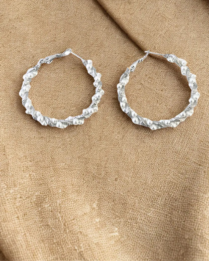Créoles élégantes en acier inoxydable argenté décorées de perles blanches. Tendance, résistantes à l’eau et hypoallergéniques, idéales pour sublimer vos looks.