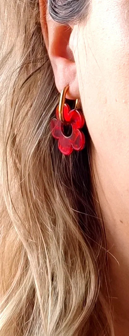 Faites rayonner votre style avec ces boucles d’oreilles dorées ornées de fleurs rouges en résine effet nacré. Leur design à la fois rétro et moderne apporte une touche de couleur vibrante et élégante à toutes vos tenues.