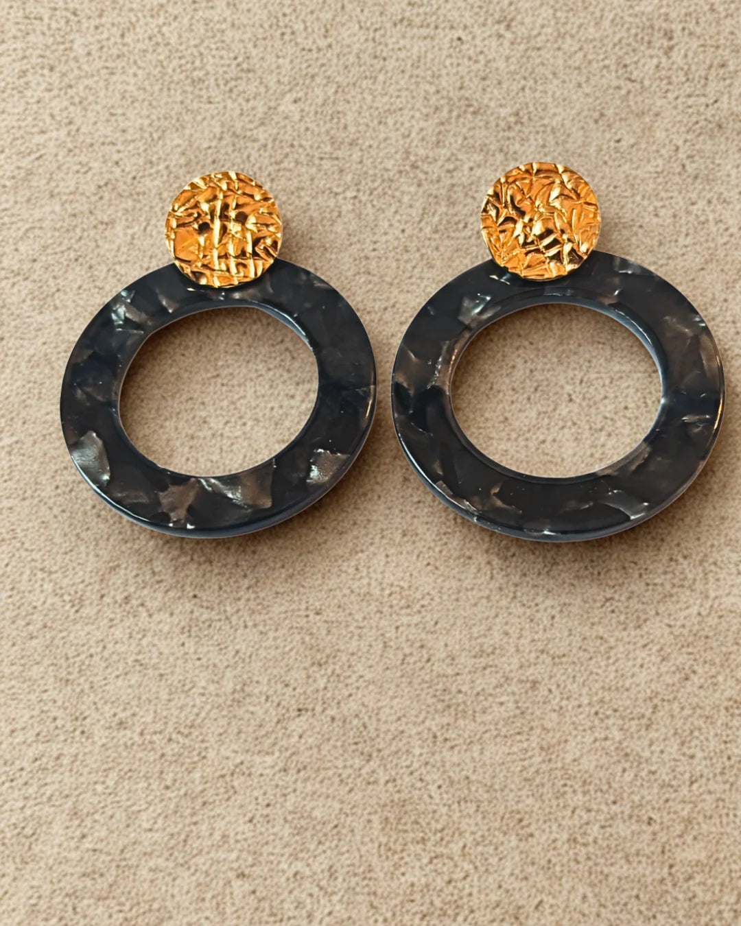Boucles d’oreilles originales en acier inoxydable doré et anneau noir effet marbré. Tendance, légères et résistantes, idéales pour un look moderne.