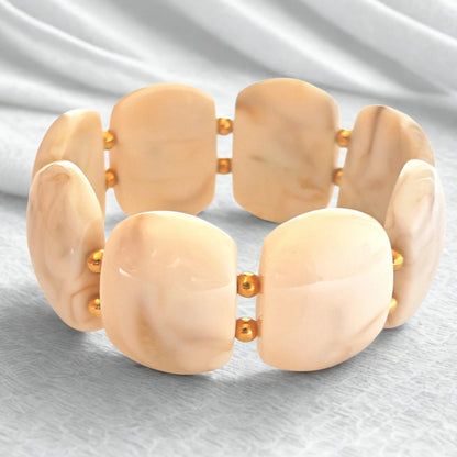 Sublimez votre poignet avec ce bracelet large en résine effet pierre naturelle, rehaussé de perles dorées en acier inoxydable. Ses reflets profonds et sa texture lumineuse en font un bijou tendance, parfait pour habiller vos tenues d’une touche chic et contemporaine.