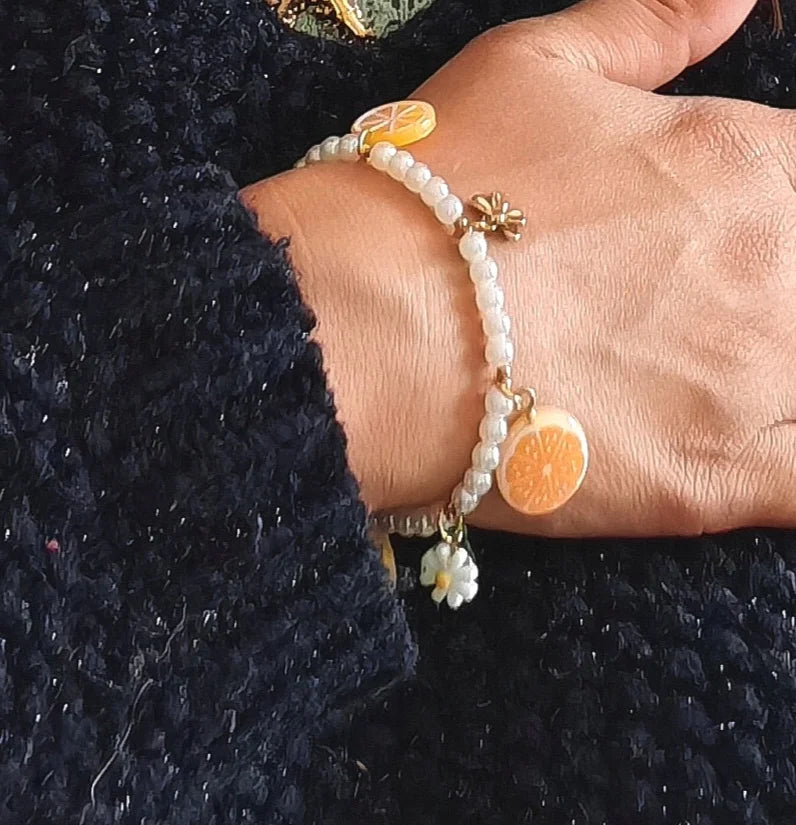 🌼 Un design vitaminé et délicat
Ce bracelet perlé se compose de perles orange éclatantes et de jolies pampilles dorées, dont des mini fleurs et des détails assortis qui rappellent les beaux jours. Léger, féminin et entièrement fabriqué en acier inoxydable, il est waterproof, hypoallergénique et ne noircit pas.

C’est le bijou idéal pour accompagner une journée ensoleillée, une balade en bord de mer ou pour ajouter une touche colorée à un look neutre.