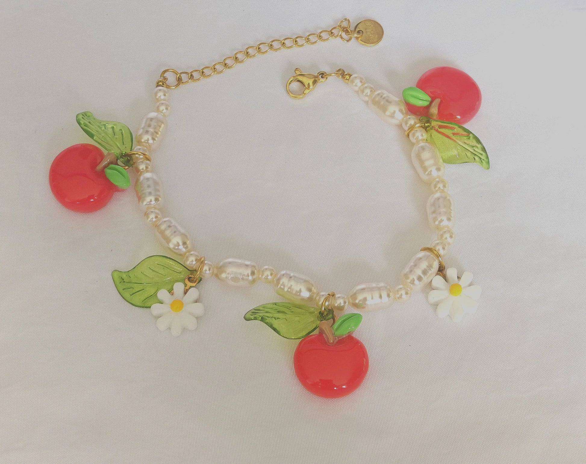 🍃 Un design ludique et raffiné
Ce bracelet délicat en acier inoxydable est orné de jolies pampilles en forme de pomme, finement travaillées, et de petites perles colorées pour une touche ludique et féminine. Waterproof et hypoallergénique, il résiste parfaitement à un usage quotidien sans perdre de son éclat.

C’est le bijou idéal pour ajouter une pointe d’originalité à une tenue décontractée ou pour sublimer une silhouette estivale.