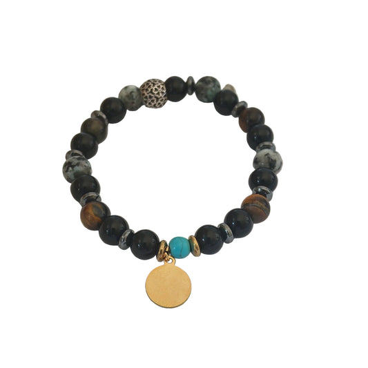 Énergie, élégance et équilibre réunis dans un bijou unique. Ce bracelet en pierres naturelles combine les vertus du Jaspe gris, de l’Onyx noir et de l’Œil de tigre pour vous apporter protection, confiance et vitalité au quotidien. Orné d’un médaillon doré personnalisable, il devient un véritable talisman personnel et symbolique.