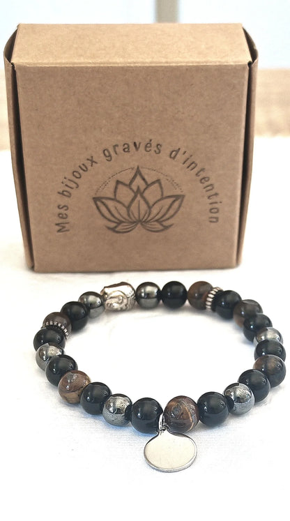 Alliez élégance et énergie avec ce bracelet en pierres naturelles, conçu pour apporter protection, ancrage et confiance en soi. Composé d’Onyx noir, d’Hématite et d’Œil de tigre, il associe la puissance de trois pierres complémentaires, renforcé par un médaillon personnalisable en acier inoxydable argenté.