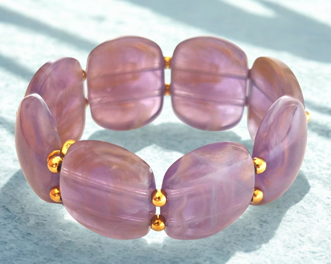 Sublimez votre poignet avec ce bracelet large en résine effet pierre naturelle, rehaussé de perles dorées en acier inoxydable. Ses reflets profonds et sa texture lumineuse en font un bijou tendance, parfait pour habiller vos tenues d’une touche chic et contemporaine.
