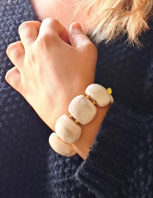 Sublimez votre poignet avec ce bracelet large en résine effet pierre naturelle, rehaussé de perles dorées en acier inoxydable. Ses reflets profonds et sa texture lumineuse en font un bijou tendance, parfait pour habiller vos tenues d'une touche chic et contemporaine.