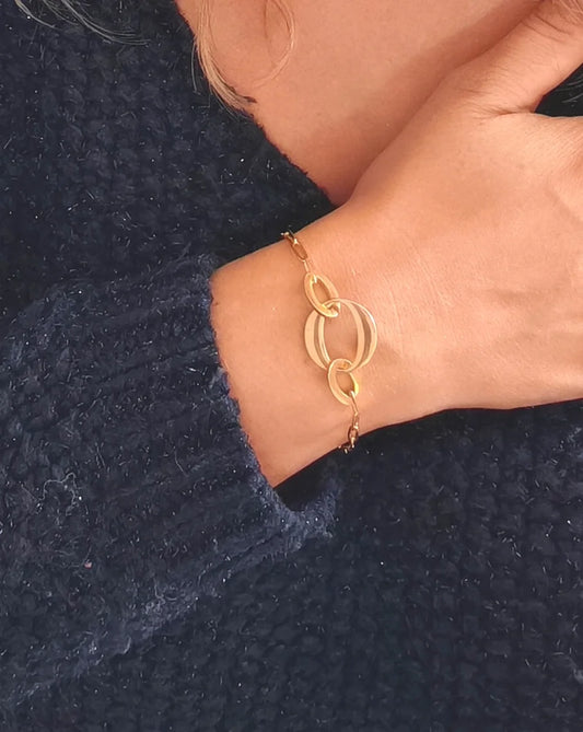 Bracelet doré en acier inoxydable avec maillons et anneaux entrelacés. Résistant à l’eau, hypoallergénique et chic, parfait pour un style moderne.