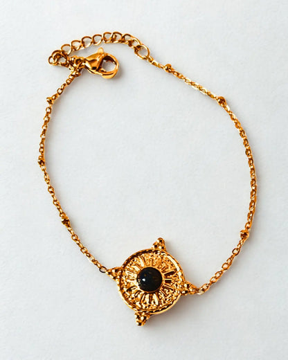Bracelet raffiné en acier inoxydable doré orné d’un soleil et d’une pierre noire. Élégant, symbolique et résistant à l’eau, idéal à offrir ou à porter au quotidien.