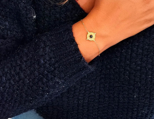 Bracelet raffiné en acier inoxydable doré orné d’un soleil et d’une pierre noire. Élégant, symbolique et résistant à l’eau, idéal à offrir ou à porter au quotidien.