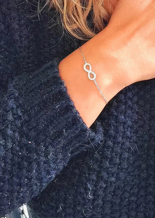 Bracelet délicat en acier inoxydable argenté avec pendentif infini. Élégant, résistant à l’eau et hypoallergénique, symbole d’éternité et d’amour infini.