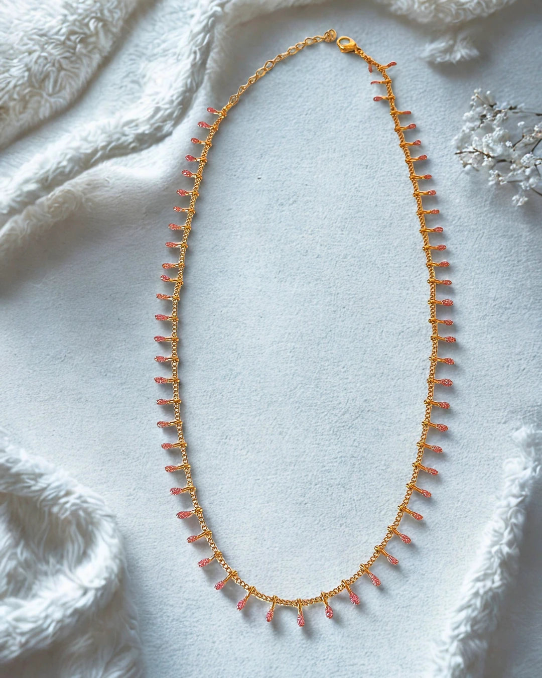 Laissez-vous charmer par la finesse de ce collier doré orné de petites pampilles roses. À la fois délicat et lumineux, il apporte une touche de couleur subtile et féminine à votre décolleté. Idéal pour sublimer vos tenues du quotidien comme vos looks de soirée.