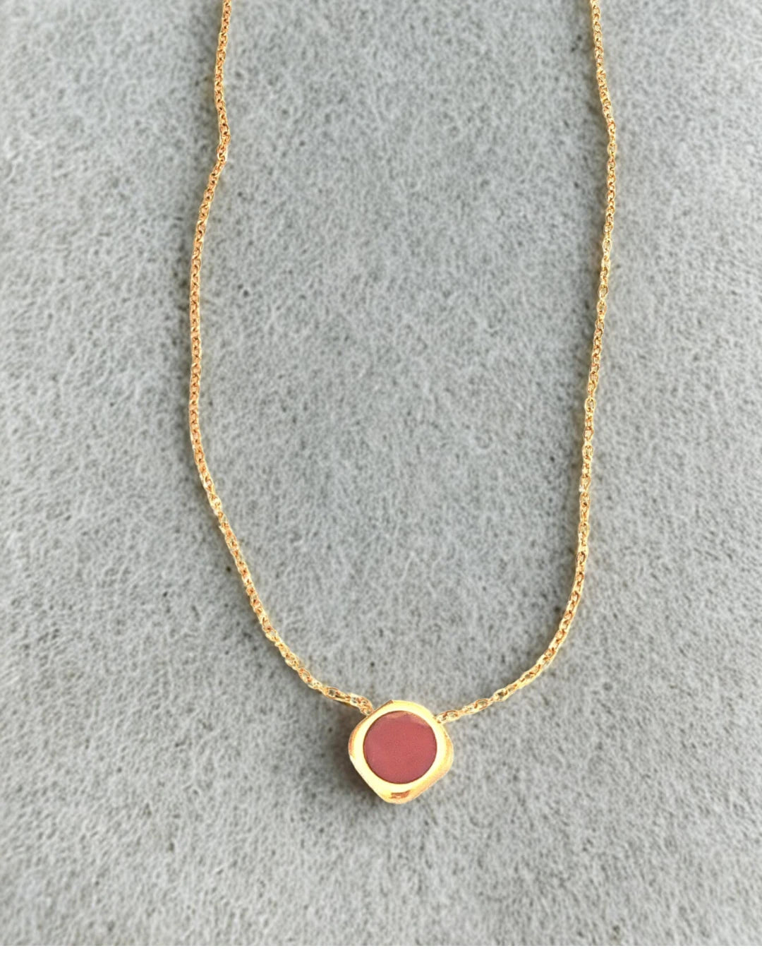 Minimaliste et raffiné, ce collier doré se distingue par son pendentif rond émaillé d’un ton chaud et doux. Parfait pour sublimer votre cou avec simplicité, il apporte une touche de couleur élégante à toutes vos tenues, du quotidien aux occasions spéciales.