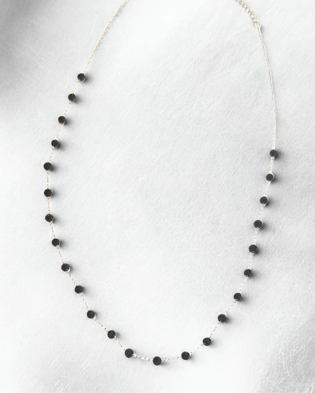 Sublimez votre décolleté avec ce collier délicat en acier inoxydable argenté orné de petites perles noires. À la fois discret et raffiné, il apporte une touche d’élégance subtile à toutes vos tenues. Un bijou intemporel à porter seul pour un look minimaliste ou en superposition pour un style moderne et féminin.

