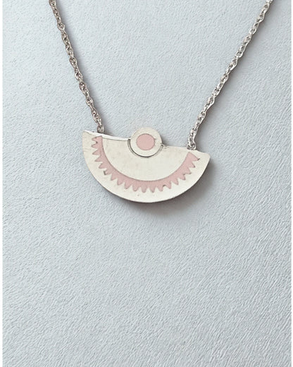 Laissez-vous séduire par l’élégance minimaliste de ce collier demi-lune en acier inoxydable argenté. Son pendentif délicatement gravé aux tons rosés évoque la douceur et l’équilibre, pour un bijou à la fois moderne et symbolique.