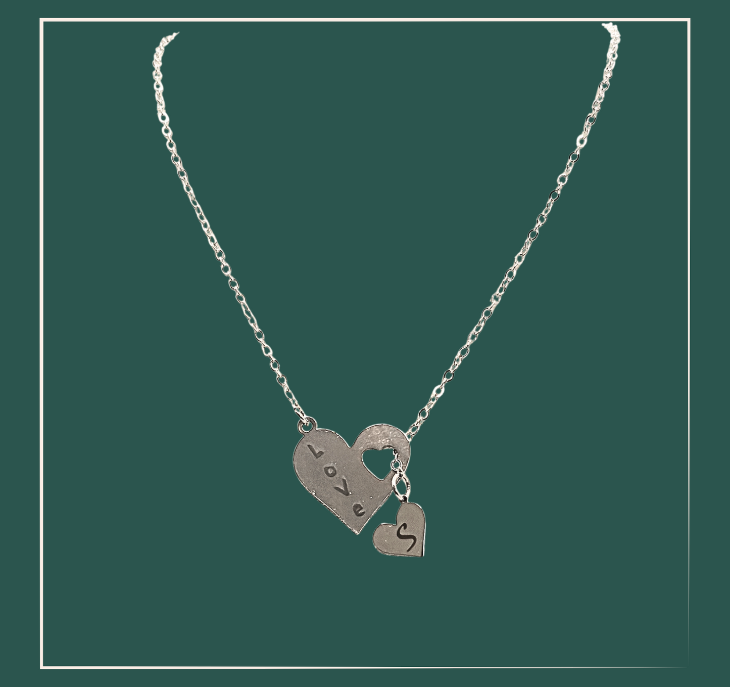 Collier deux cœurs personnalisable - acier inoxydable  Ce collier deux cœurs est personnalisable avec un grand cœur pour montrer votre amour et un petit cœur pour une initiale. Exprimez vos sentiments avec élégance grâce à ce collier unique. Fabriqué avec soin pour durer dans le temps. Existe en collier argent fantaisie ou en collier doré fantaisie qui se marieront avec tous les styles. Le collier personnalisé acier inoxydable est le cadeau idéal pour faire plaisir à celle qui vous est si precieuse.