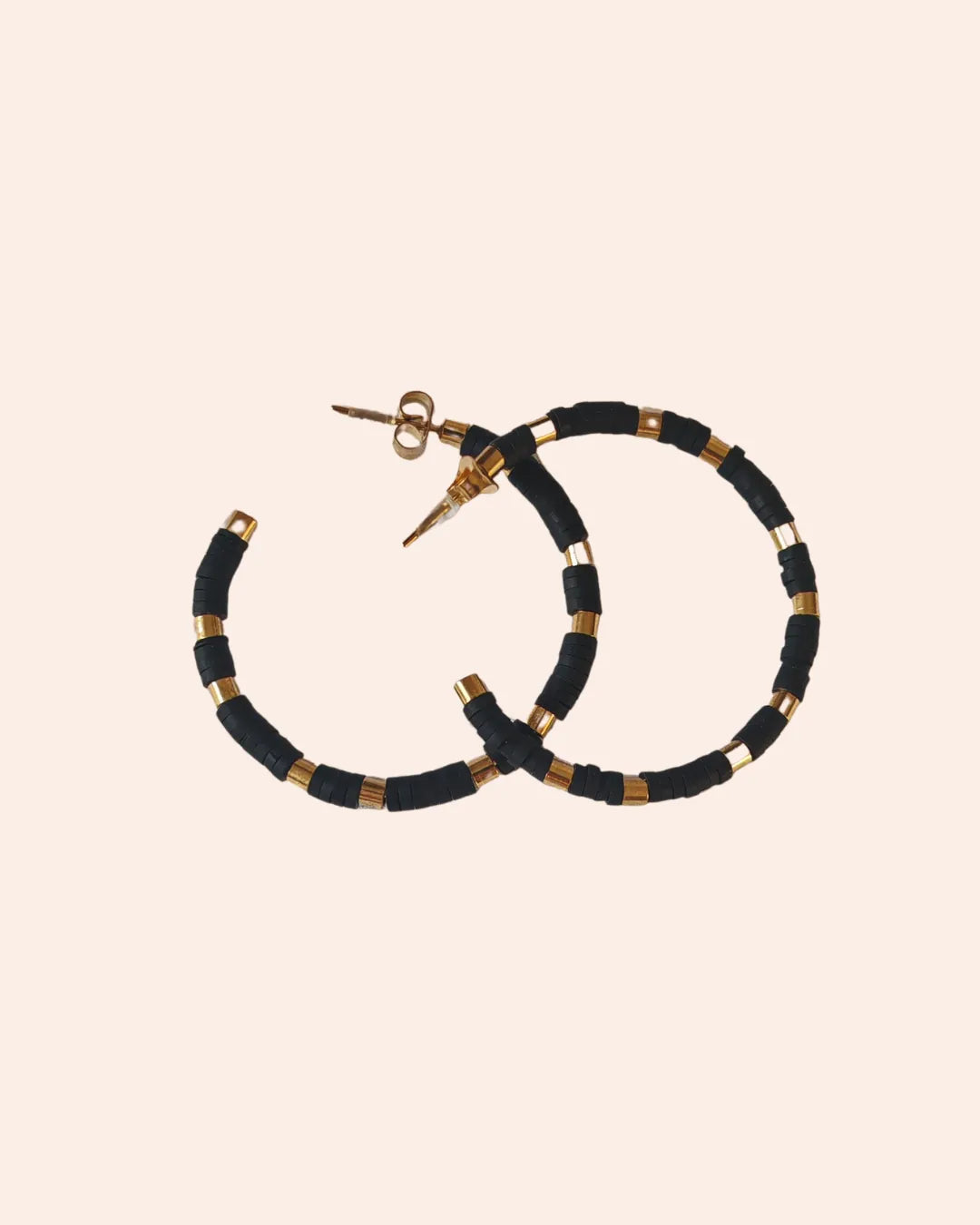 Les boucles d’oreilles créoles noires et dorées allient modernité et raffinement. Leur design audacieux et chic en fait un accessoire indispensable pour rehausser toutes vos tenues, du look casual au plus habillé.