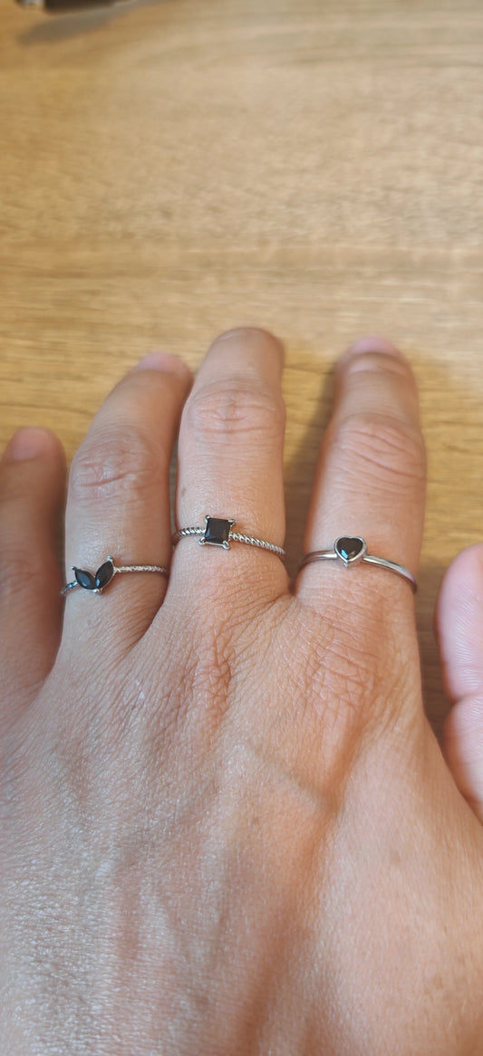 Set de 3 bagues en acier inoxydable argenté ornées de pierres noires. Élégantes, résistantes à l’eau et hypoallergéniques, à porter seules ou en stacking tendance.