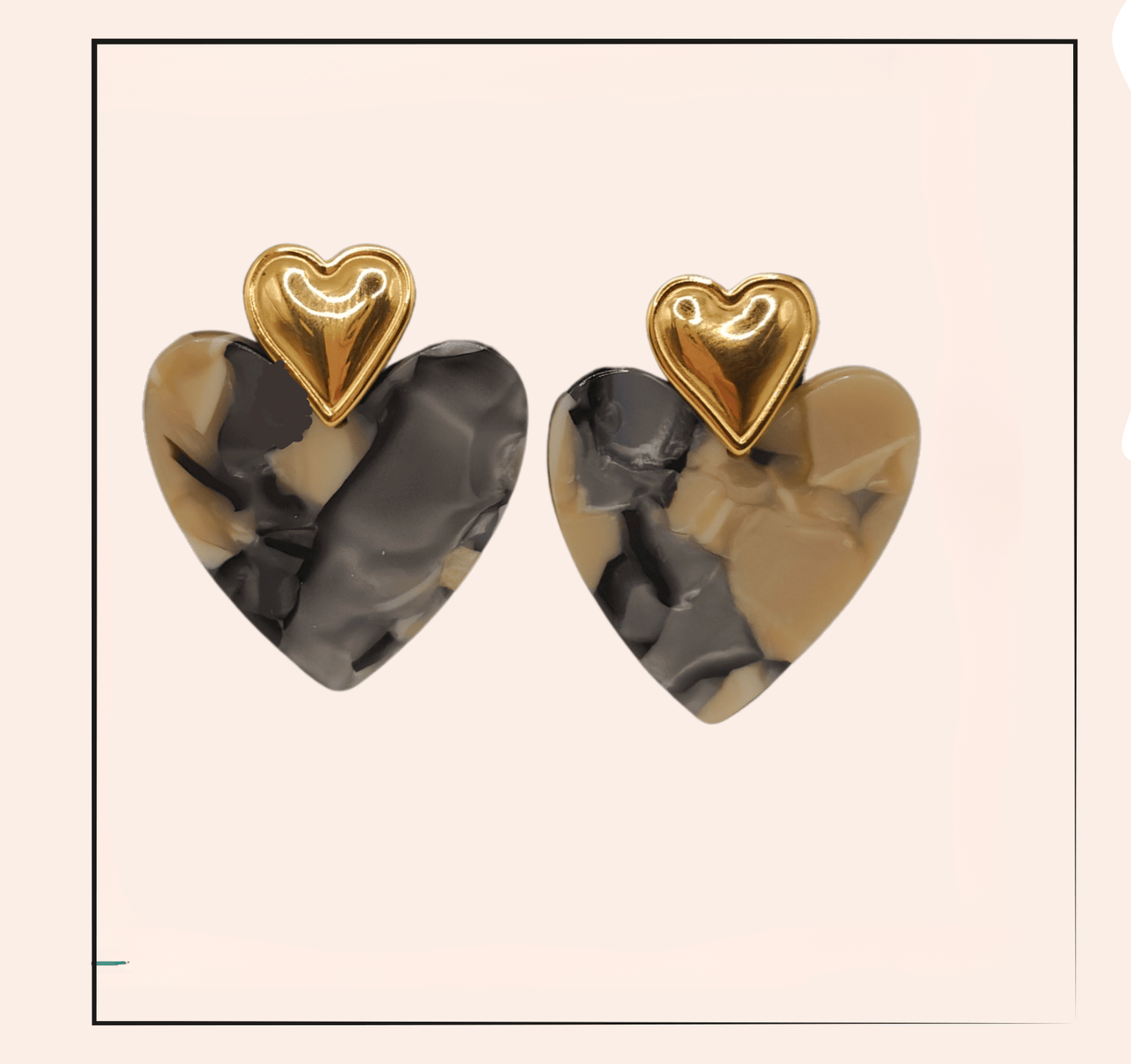Boucle d'oreille acier inoxydable Cléa - acier inoxydable  Les boucles d'oreilles Cléa en acier inoxydable doré, en forme de cœur, allient élégance et durabilité. Leur design marbré gris et beige ajoute une touche sophistiquée, tout en étant anti-allergique