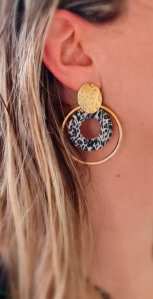 Boucle d'oreille acier inoxydable Saya - acier inoxydable  La boucle d'oreille en acier inoxydable doré Sayaest un accessoire élégant et polyvalent qui ajoutera une touche de sophistication à n'importe quelle tenue. Avec ses doubles anneaux mouchetés de noir et beige, elle incarne le mariage parfait de la modernité et de l'élégance classique. Découvrez une nouvelle façon de porter un accessoire de mode intemporel avec la boucle d'oreille Saya. .