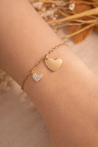Bracelet cœur doré en acier inoxydable avec médaille personnalisable et petit cœur strass porté au poignet