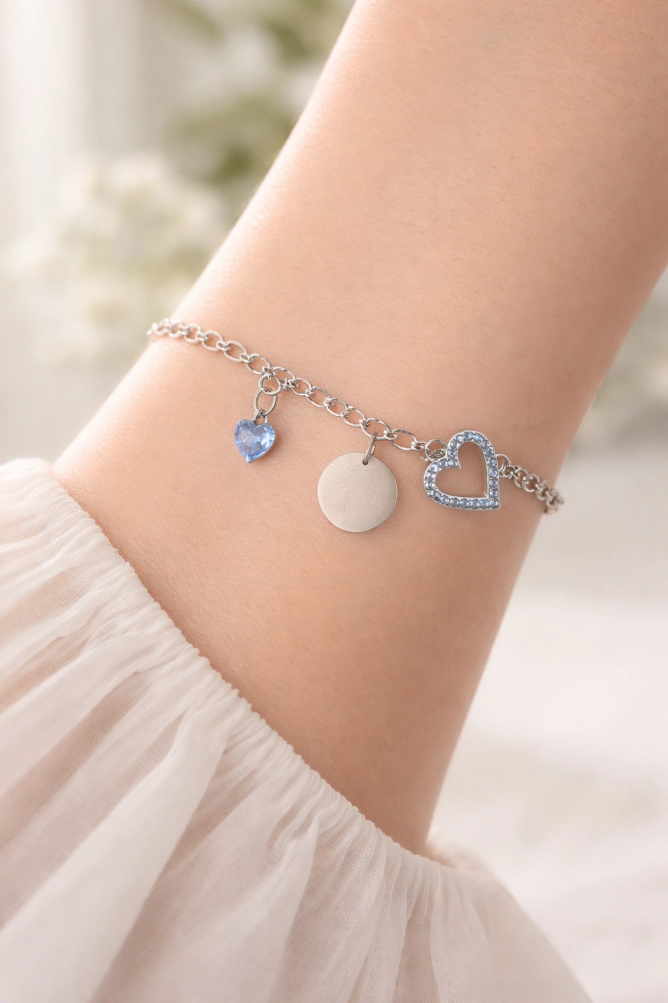 Bracelet personnalisable argent avec charms cœur bleu et médaille gravable porté au poignet