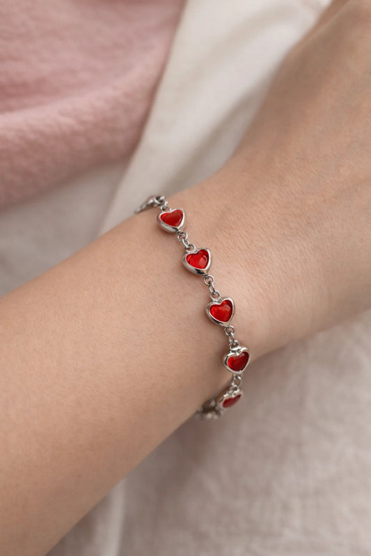 Un bracelet chaîne en acier inoxydable argent orné de cœurs rouges, symbole d’amour et d’élégance au quotidien.