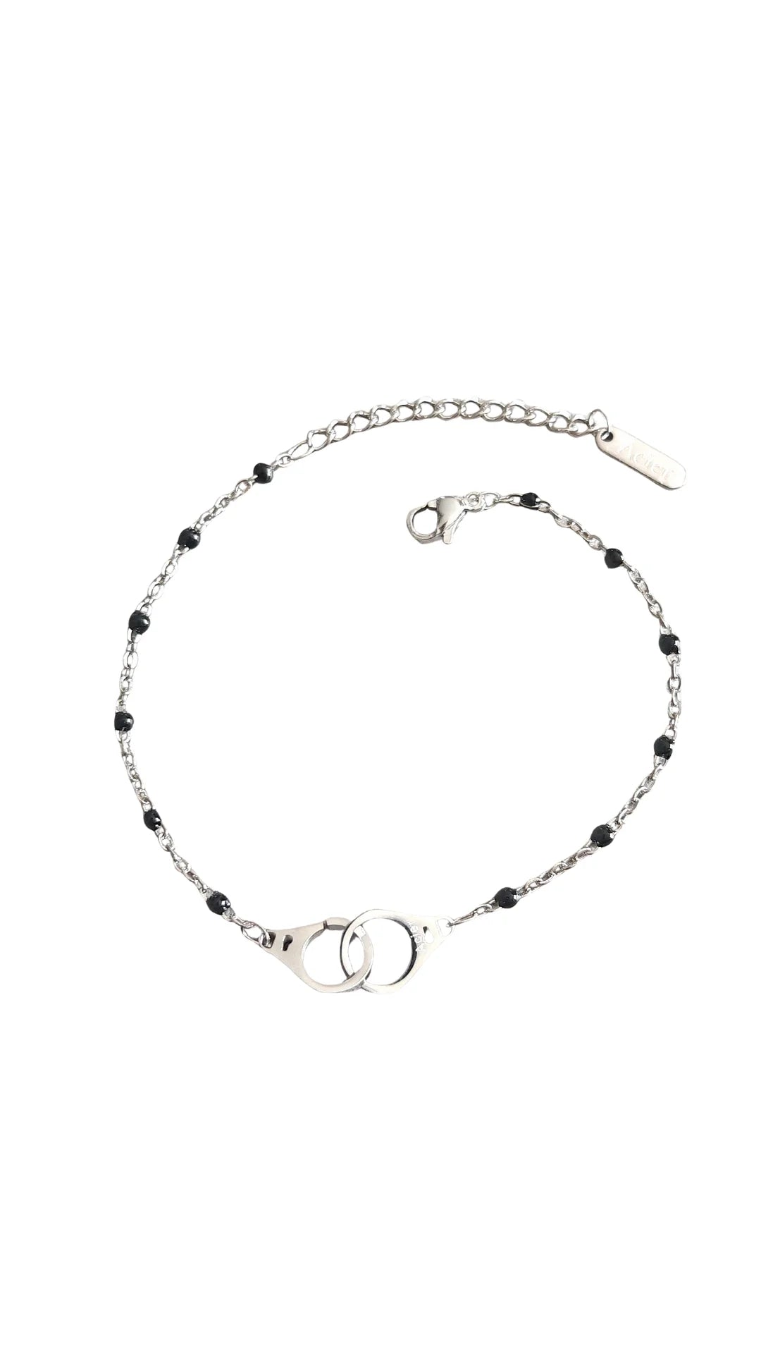 Bracelet raffiné en acier inoxydable argenté avec pendentif menottes. Résistant à l’eau et hypoallergénique, symbole de lien, de complicité et de liberté.