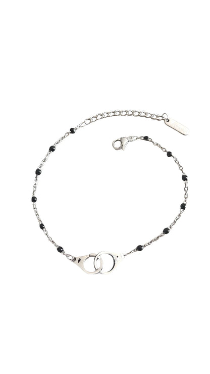 Bracelet raffiné en acier inoxydable argenté avec pendentif menottes. Résistant à l’eau et hypoallergénique, symbole de lien, de complicité et de liberté.