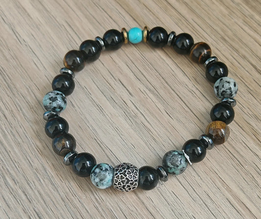 L’équilibre puissant des pierres naturelles

Chaque pierre de ce bracelet a été choisie pour sa vibration complémentaire :

L’onyx noir apaise, stabilise les émotions et renforce l’ancrage.

L’hématite agit comme un miroir protecteur contre les ondes négatives.

L’œil de tigre repousse les énergies toxiques tout en favorisant la confiance en soi.