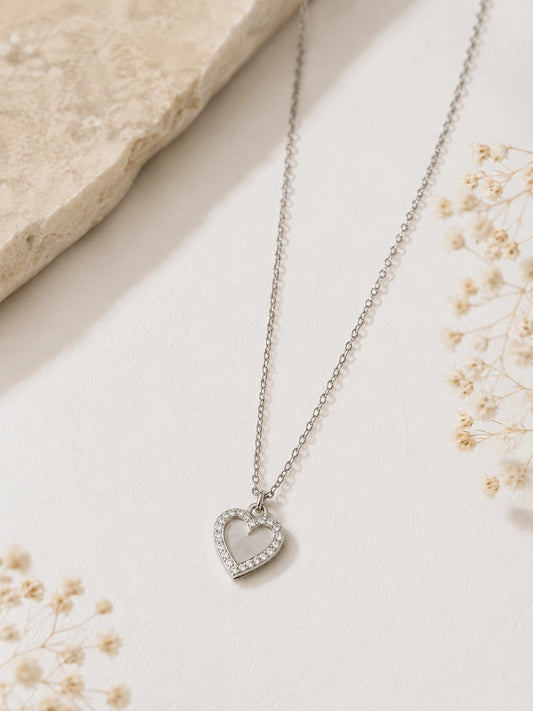 Collier cœur argenté avec strass en acier inoxydable porté par une femme
