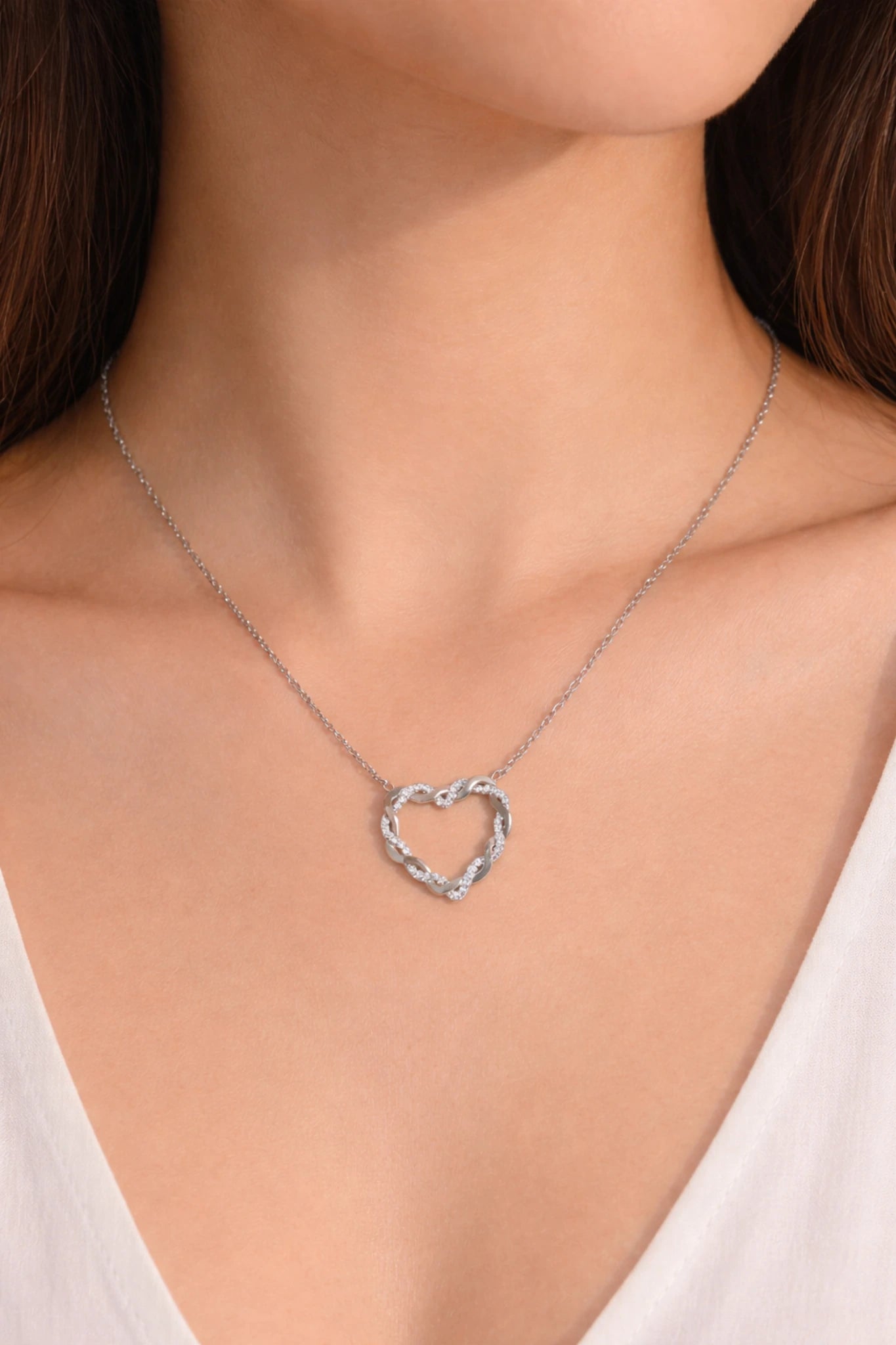 : collier cœur entrelacé en acier inoxydable argent porté autour du cou