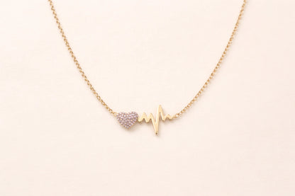 Collier cœur battement de cœur doré en acier inoxydable avec strass sur fond blanc