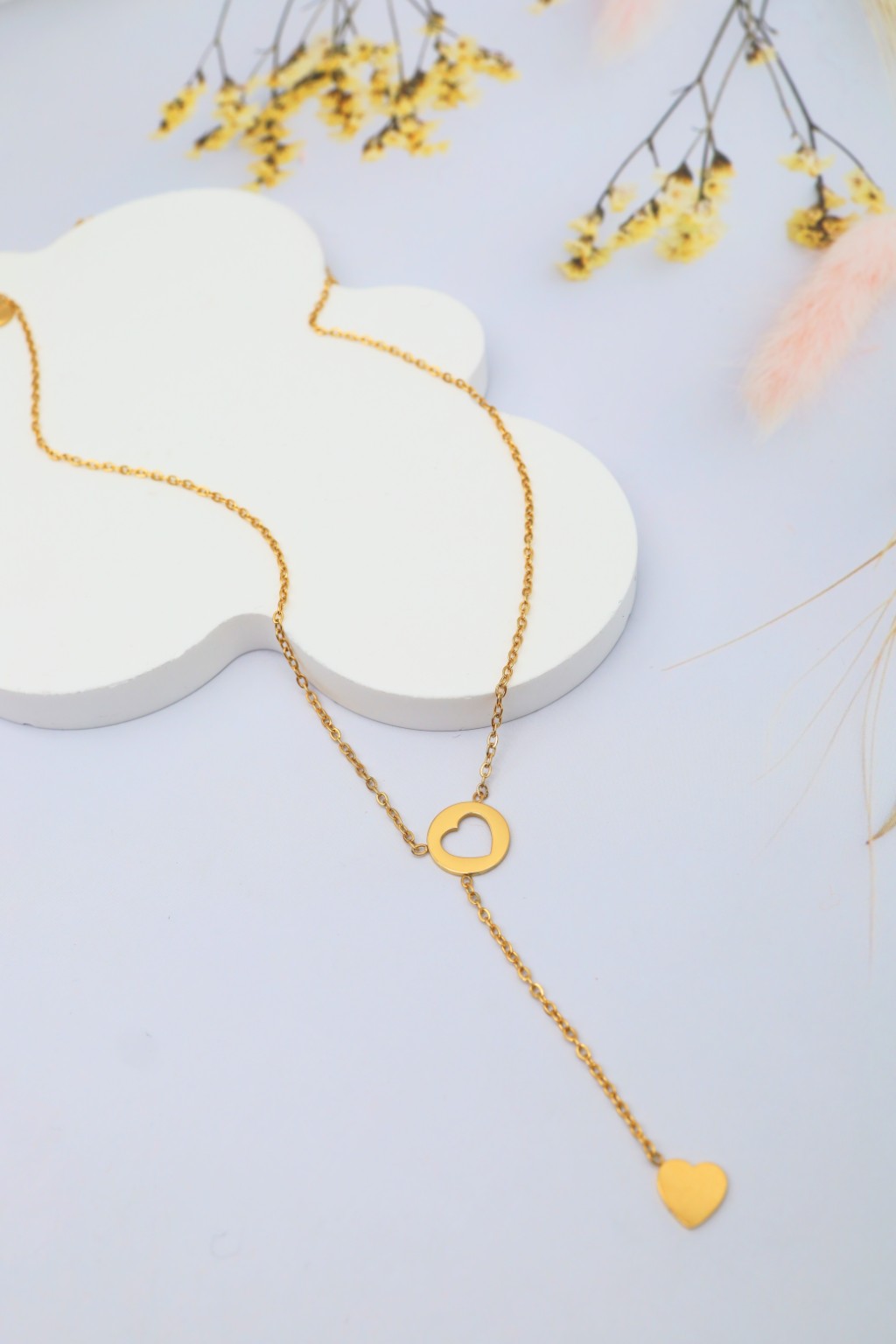Collier double cœur en Y doré sur présentoir blanc