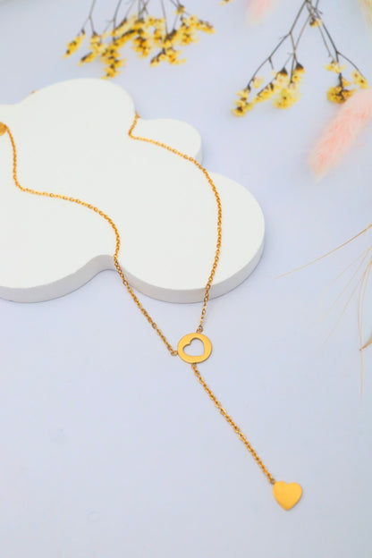 Collier double cœur en Y doré sur présentoir blanc